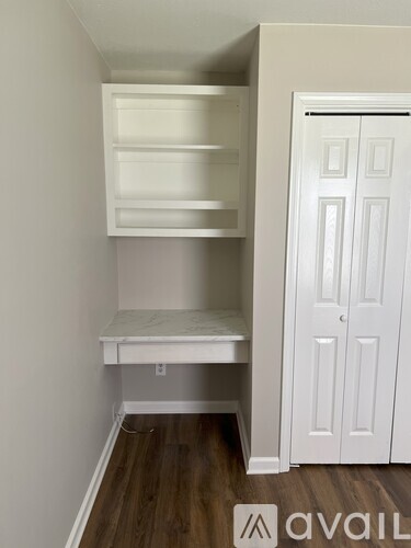 A white closet with shelves and a bench is shown.