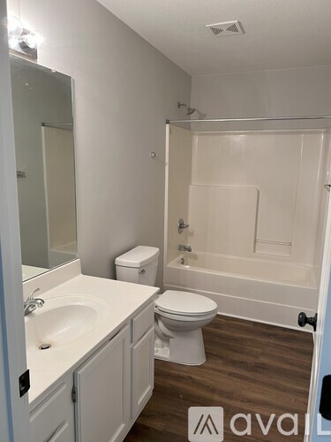 A white bathroom with a toilet, sink, and bathtub.