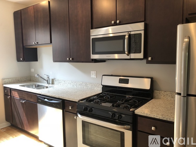 A kitchen with a stove, microwave, and refrigerator.