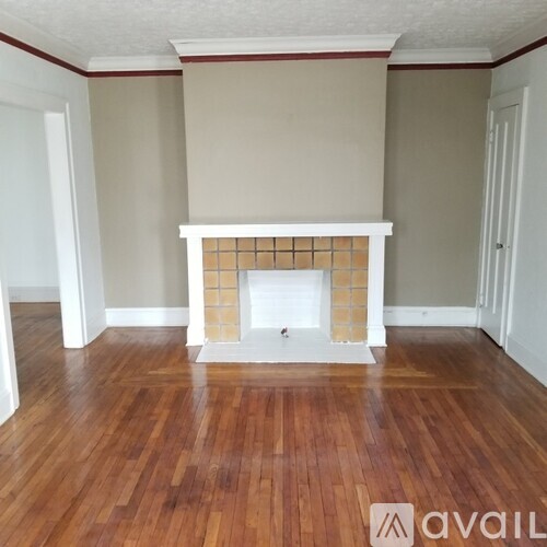 A room with a fireplace and wooden floors.
