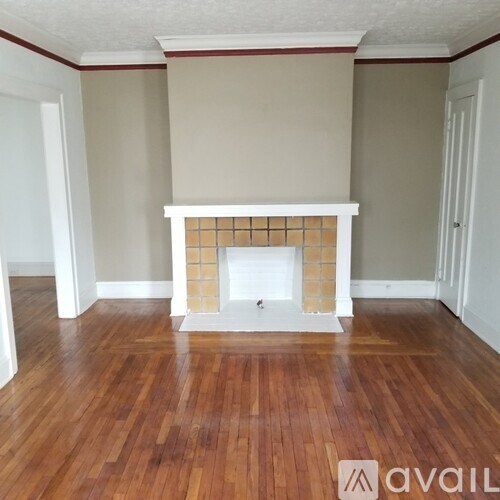 A room with a fireplace and wooden floors.