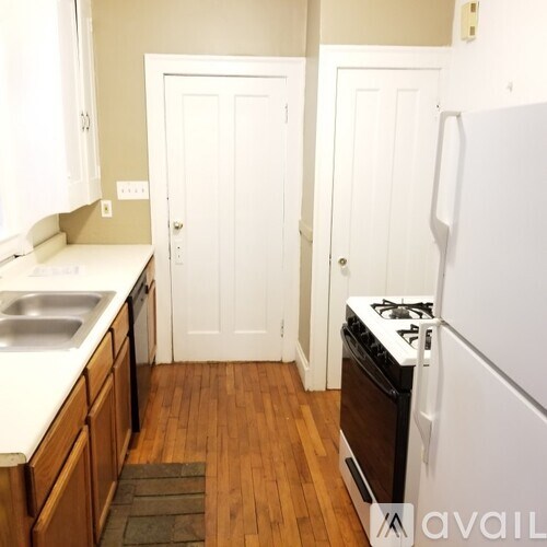 A kitchen with a white fridge and a white door.