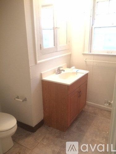 A small bathroom with a toilet, sink and window.
