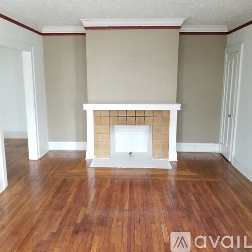 A room with a fireplace and wooden floors.