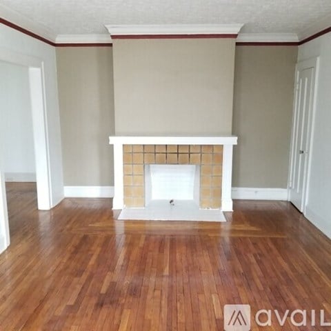 A room with a fireplace and wooden floors.
