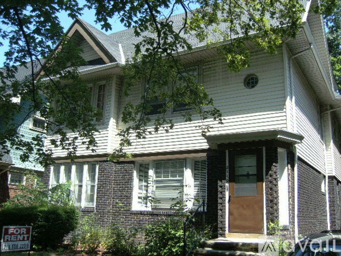 A house with a "For Rent" sign in front of it.