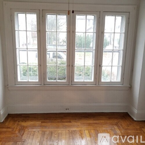A room with a large window and wooden flooring.