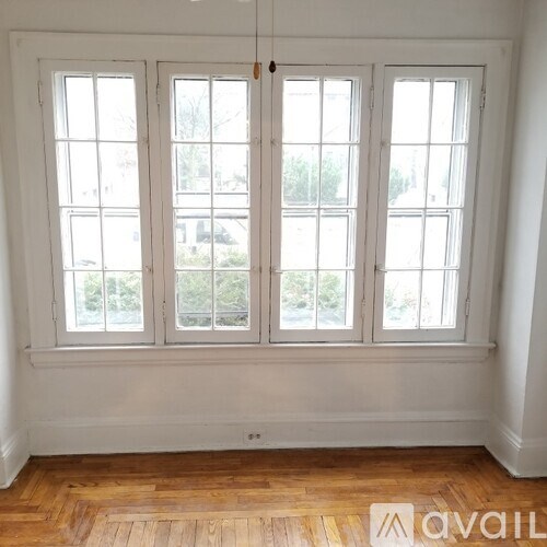 A room with a large window and wooden flooring.