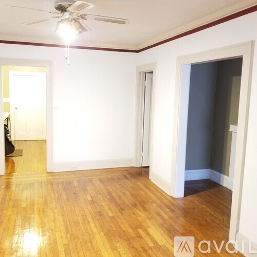 A room with wooden floors and a ceiling fan.