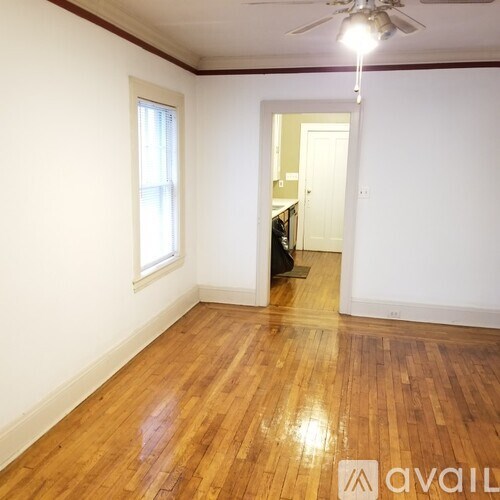 A room with wooden flooring and a ceiling fan.