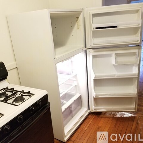 A white refrigerator with its door open is in a kitchen.