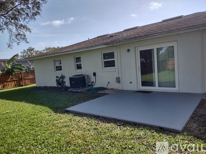 A house with a white exterior and a grey ramp in front.