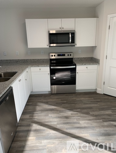 A kitchen with white cabinets and a black stove top oven.