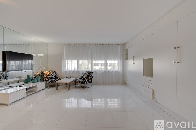 A modern living room with a white floor and a large mirror on the wall.