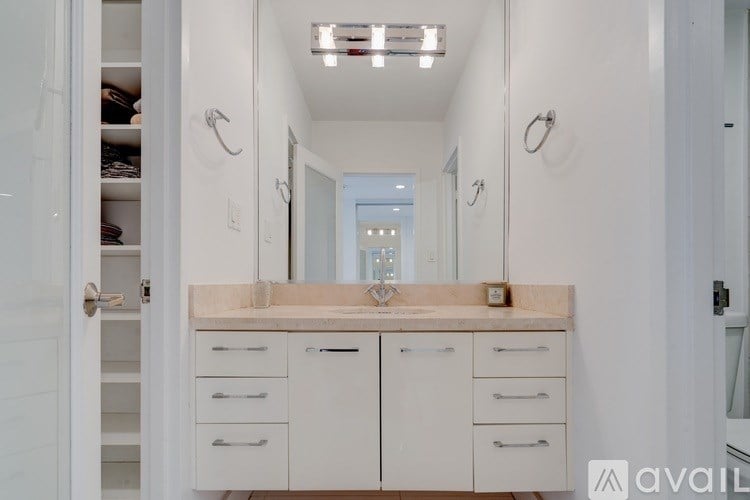 A bathroom with a sink, mirror, and cabinets.