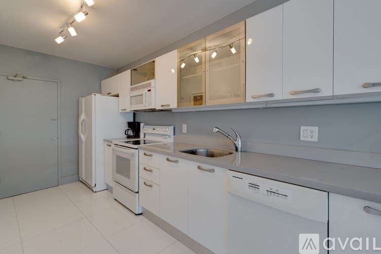 A modern kitchen with white appliances and cabinets.