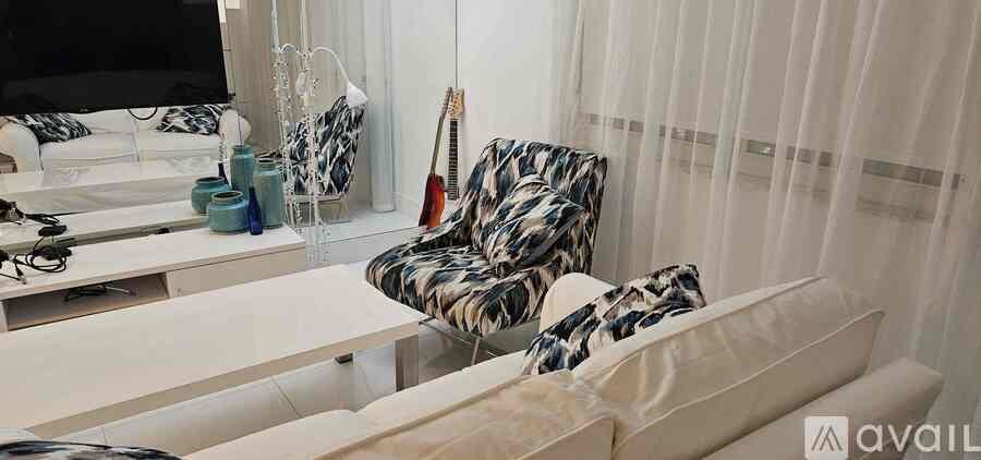 A living room with a couch, chair, and television.