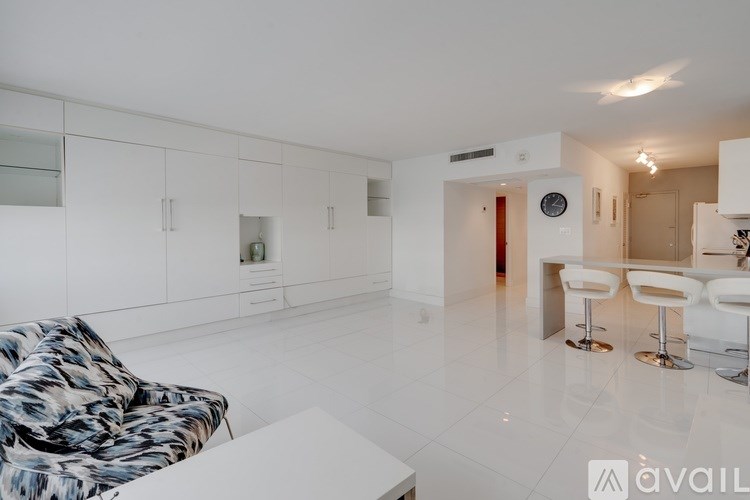 A living room with a white couch and a patterned chair.
