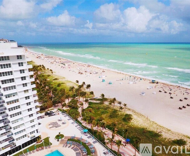A beachfront view with a hotel and a swimming pool.
