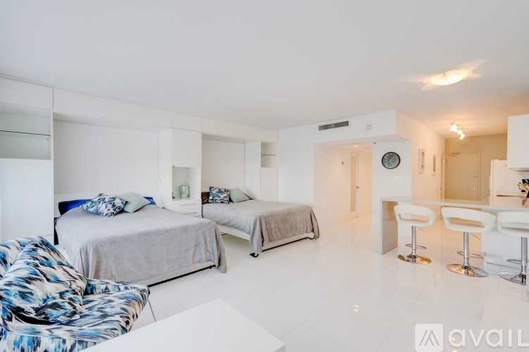A white bedroom with two beds and a desk.