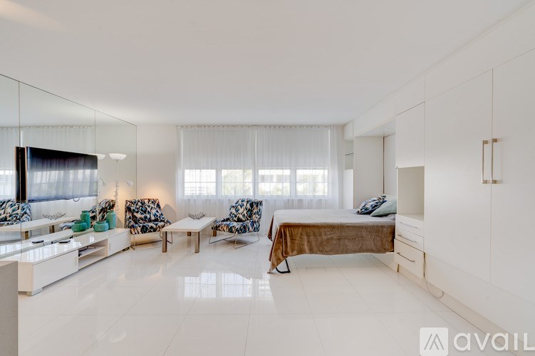 A bedroom with a large bed, a couch, and a chair.