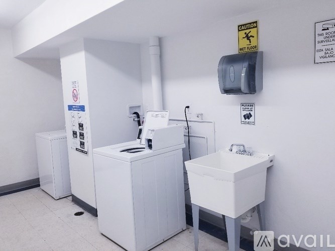 A bathroom with a toilet, sink, and a caution sign on the wall.