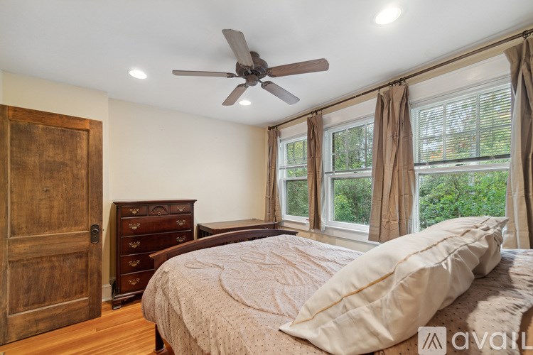 A bedroom with a bed, dresser, and window.