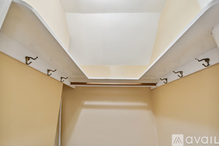 A white ceiling with a row of hooks on the wall.