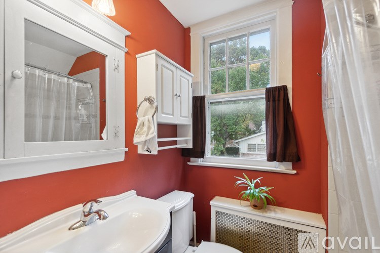 A bathroom with orange walls and a white sink.