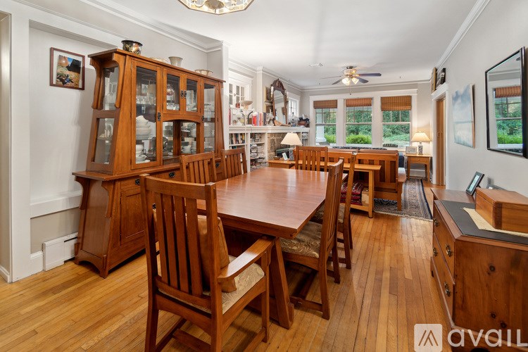 A wooden dining room with a large table and chairs.