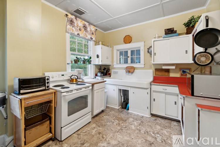 A kitchen with a white refrigerator, oven, and cabinets.
