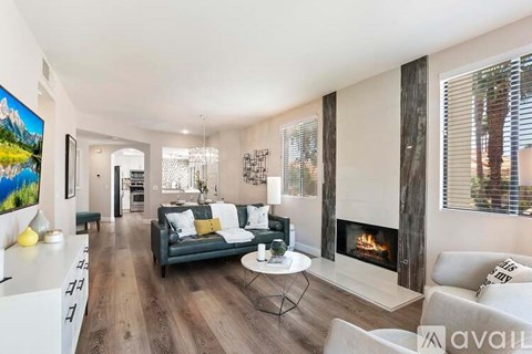 A living room with a fireplace and a painting on the wall.