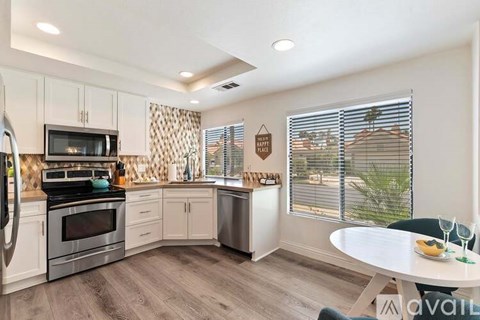 A kitchen with a table and chairs in front of a window.
