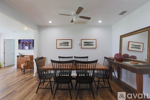 A dining room with a wooden table and chairs.