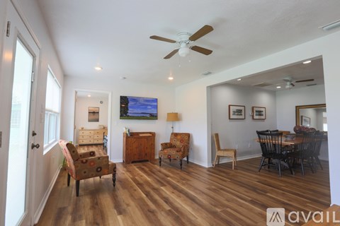 A living room with a television and a dining table.