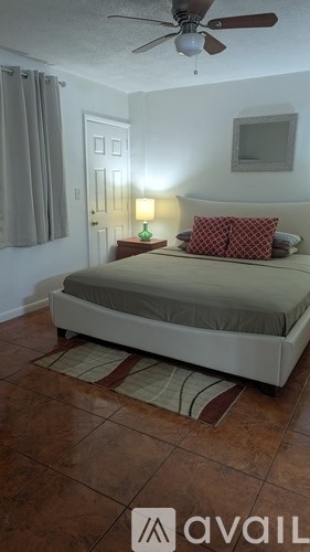 A bedroom with a bed, nightstand, and lamp.