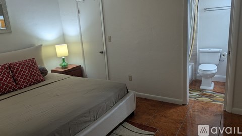 A bedroom with a bed, nightstand, and lamp.