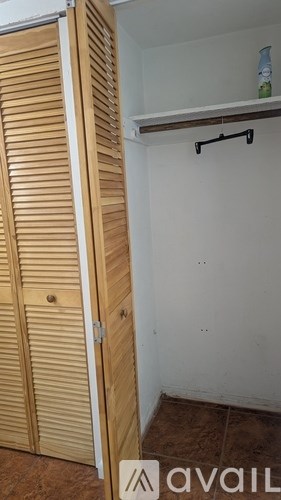A wooden closet with a shelf above it.