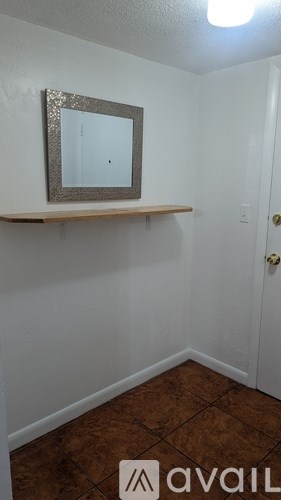 A room with a mirror and a shelf.