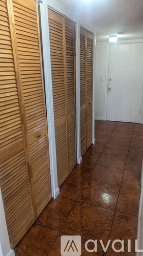 Closet with wooden doors and brown floor.