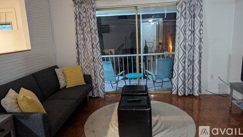 A living room with a grey couch and a black coffee table.