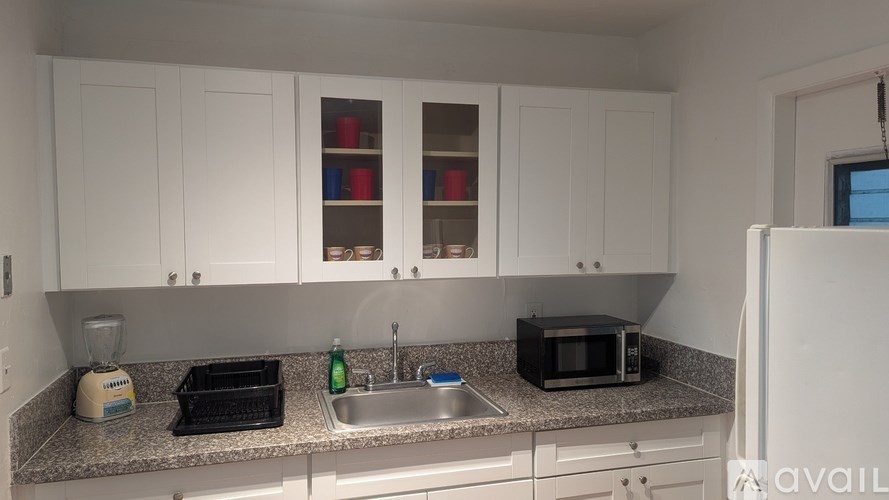 A kitchen with white cabinets and a granite countertop.
