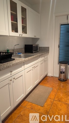 A kitchen with white cabinets and a black stove top.