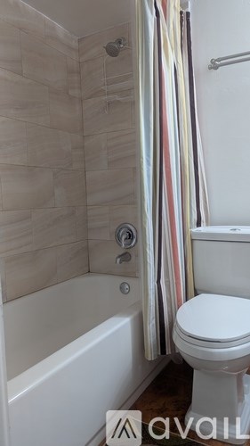 A bathroom with a toilet, tub, and shower curtain.