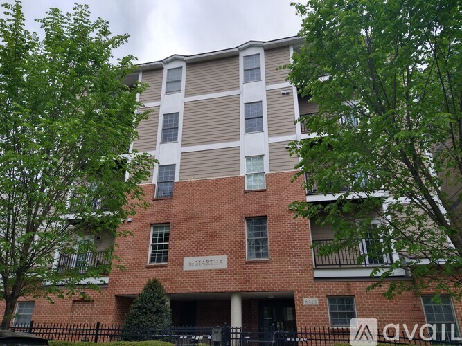 The Martha apartment building is a multi-story brick building with a mix of beige and white siding.