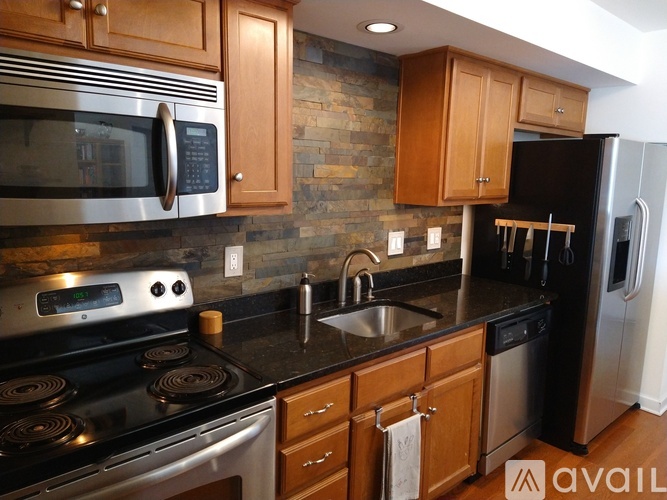 A kitchen with wooden cabinets and a black stove top oven.