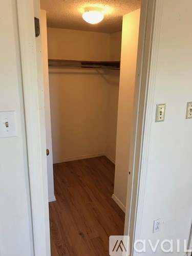 A small, empty room with wooden floors and white walls.