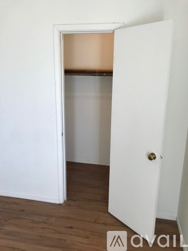 A white door is open to a small room.