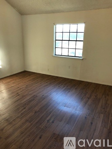 A room with wooden flooring and a window.