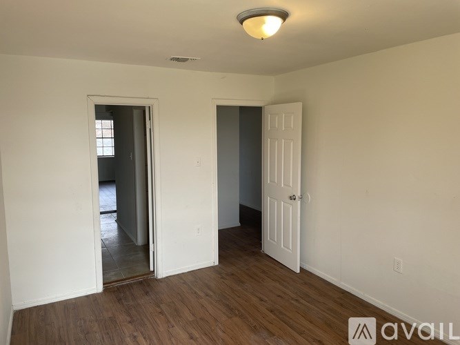 A room with a white door and a window with a view of the street.